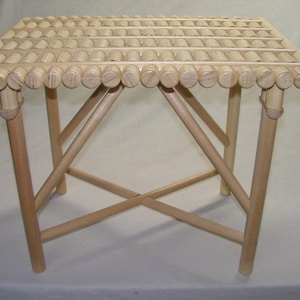 May include: A light wood folding stool with a slatted top made of round wooden dowels.