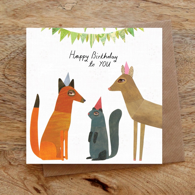 Puede incluir: Una tarjeta de cumplea&ntilde;os con un zorro, un ciervo y una ardilla que llevan sombreros de fiesta. La tarjeta tiene una pancarta verde y blanca con el texto "Happy Birthday to YOU".