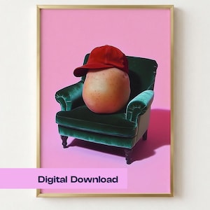 May include: A framed wall art print featuring a potato wearing a red baseball cap, sitting in a dark green velvet armchair against a solid pink background. The bottom of the print includes the text Digital Download in a dark purple font.