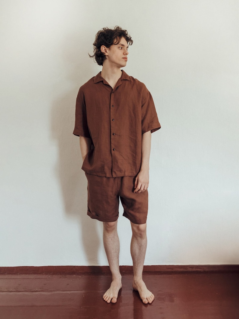 May include: A person wearing a brown linen short-sleeved shirt and matching shorts. The shirt has a collar and button closure.