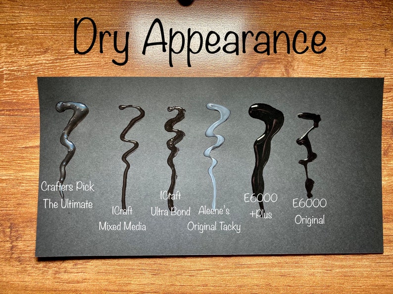 May include: A black card displays six wavy lines of different adhesives, each labeled with its brand and type. The text "Dry Appearance" is at the top. The adhesives vary in color from dark gray to black and light gray.