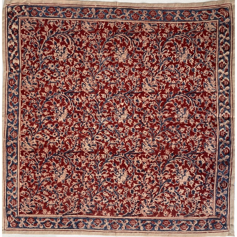 Puede incluir: Una tela con estampado floral rojo y azul con un borde blanco. La tela tiene un patr&oacute;n repetitivo de flores y hojas.