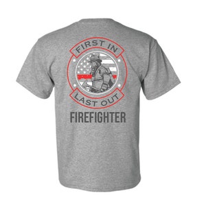 May include: Gray t-shirt with a red circle graphic featuring a firefighter with an American flag and the text "First In Last Out Firefighter".