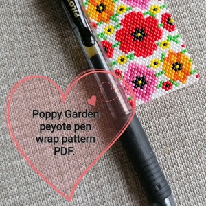 May include: A close-up of a black pen with the text "PILOT G-2 07" on the side. The pen is lying on a white surface with a colorful beaded poppy flower design. The text "Poppy Garden peyote pen wrap pattern PDF." is written in a pink heart shape.