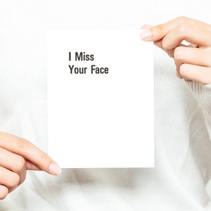 May include: A white card with the text "I Miss Your Face" written in black.