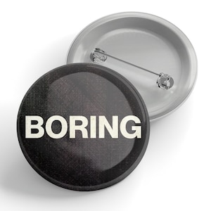 May include: A black button with a white background and the word "BORING" printed in white letters.
