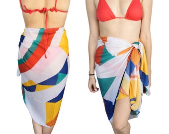 May include: A white sarong with a geometric pattern in shades of red, yellow, blue, and green. The sarong is tied around the waist and drapes down to the knees.