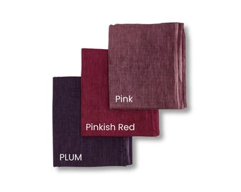 May include: Three folded fabric squares in shades of pink, pinkish red, and plum. The top square is labeled "Pink", the middle square is labeled "Pinkish Red", and the bottom square is labeled "PLUM". The fabrics are stacked on a white background.