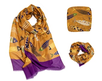May include: A mustard yellow scarf with a purple border and a pattern of colorful fish. The scarf is folded and displayed on a white background.