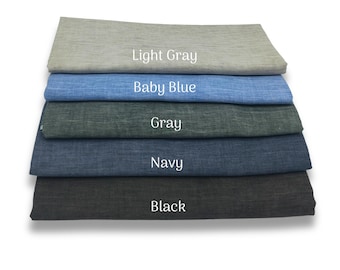 May include: A stack of fabric samples in various shades of blue, gray, and black. The colors are labeled: Light Gray, Baby Blue, Gray, Navy, and Black. The fabric has a textured appearance.