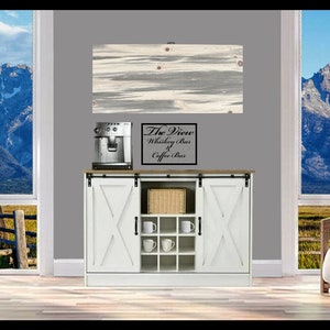 May include: White cabinet with sliding barn doors, a wine rack, and a coffee maker. The cabinet has a wooden top and a sign that reads "The View Whiskey Bar & Coffee Bar".