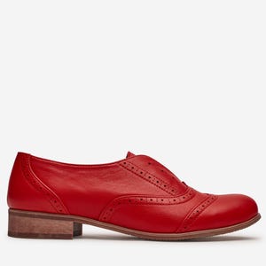 Könnte beinhalten: Ein einzelner roter Lederschuh im Oxford-Stil mit dekorativen Perforationen. Der Schuh hat einen niedrigen, gestapelten Absatz und ein klassisches Design. Der Schuh hat eine leuchtend rote Farbe, perfekt, um jedem Outfit einen Farbtupfer zu verleihen.