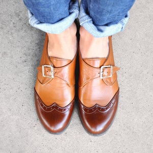 Comfortable dress shoes with delicate brogue details, sleek elegant soles and gold tone buckles