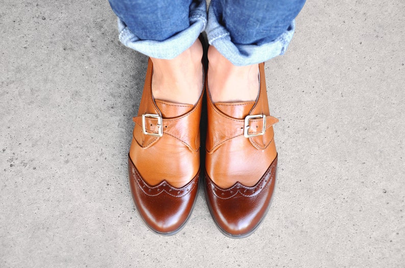 Comfortable dress shoes with delicate brogue details, sleek elegant soles and gold tone buckles