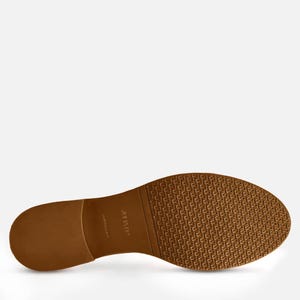 May include: A close-up of the sole of a brown leather shoe. The sole has a textured pattern and the brand name "JULIA FO" is printed on the side. The shoe is a light brown color.