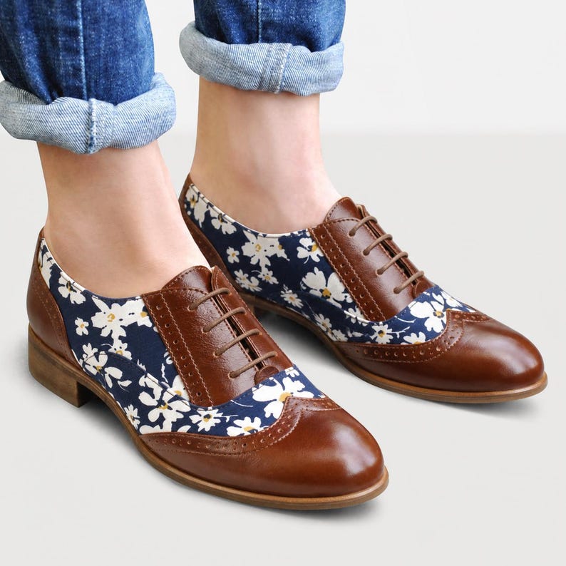 Women's brown leather shoes with floral textile inserts.