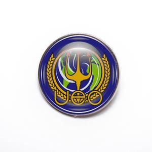 May include: A blue and gold pin featuring a trident, a globe, and the letters "UEO" within a wreath.