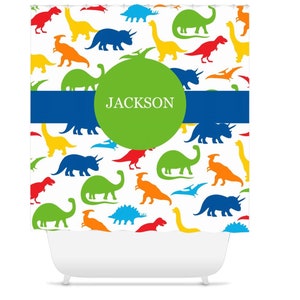 May include: A white shower curtain with a colorful dinosaur pattern and a green circle with the name "JACKSON" in white text.