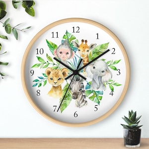 May include: A white clock with a wooden frame features a jungle animal theme. The clock face has black Roman numerals and black hands. The animals include a lion, zebra, giraffe, monkey, and elephant. The animals are surrounded by green leaves.