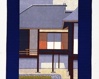 Può includere: Una stampa su legno che rappresenta una casa giapponese con un tetto blu e una struttura in legno. La casa è circondata da un giardino con un sentiero di pietra e erba verde. La stampa è incorniciata da un bordo blu scuro.