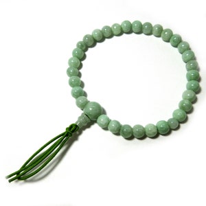 May include: A green jade prayer bead bracelet with a green tassel.