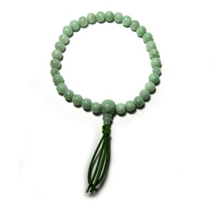 May include: A green jade beaded bracelet with a green tassel. The bracelet is made of round beads and has a simple design.