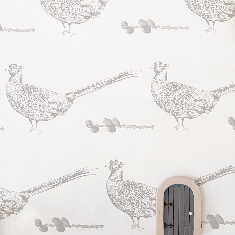 May include: A white background with a repeating pattern of gray pheasant birds and gray pine cone branches.