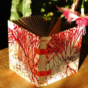 Handmade travel notebook composed of 120 pages of kraft paper, Coptic binding, available in red
