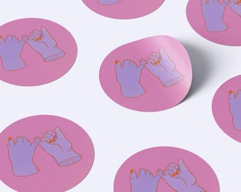 May include: A collection of circular stickers featuring a pink background with a graphic illustration of two purple hands making a pinky promise. The hands are outlined in orange, and the fingernails are painted with a bright orange color.