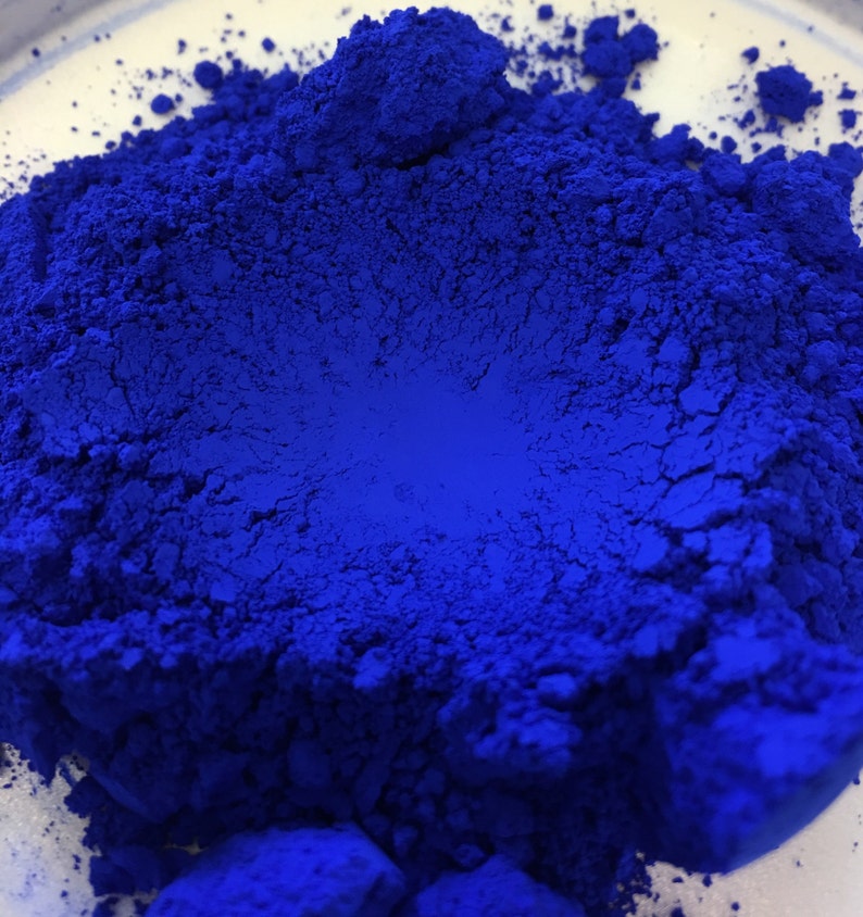 Op de afbeelding: Close-up van een levendig, diepblauw pigmentpoeder. Het poeder is fijn gemalen, met een textuur en een rijke, verzadigde kleur. De afbeelding benadrukt de intensiteit en diepte van de blauwe tint, wat suggereert dat het in kunst of cosmetica wordt gebruikt.