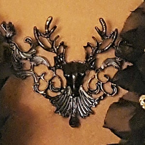 May include: A black metal deer head design with intricate details. The design is ornate and features a stylized deer head with antlers.