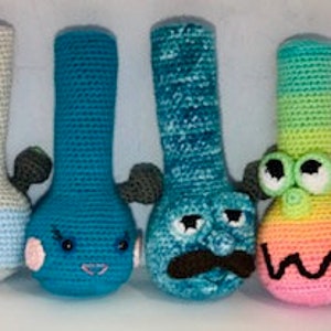 Puede incluir: Cuatro figuras de bong amigurumi de crochet. Los bongs son de varios colores, incluyendo gris, azul, azul verdoso y rosa. Cada bong tiene una cara y características únicas.