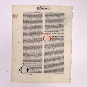May include: A page from an antique book with text in black ink on a cream-colored background. The text is in a gothic font and includes the words "Tobias" and "Obias er tri".