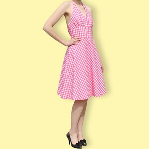 May include: A pink and white gingham halter dress with a fitted bodice and a full skirt.