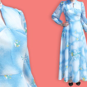 May include: A long-sleeved blue maxi dress with a white floral print. The dress has a high neck with a keyhole opening and a gathered skirt.