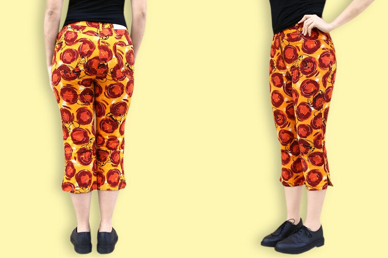 Puede incluir: Un pantal&oacute;n corto con fondo amarillo y estampado floral abstracto rojo y naranja.