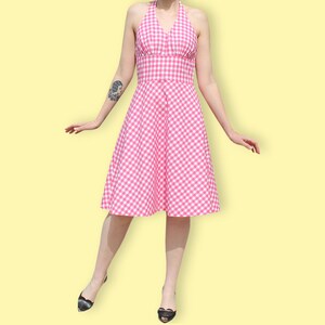 May include: A pink and white gingham halter dress with a fitted bodice and a full skirt.