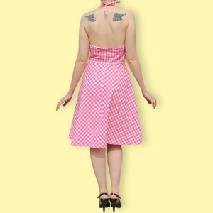 May include: A pink and white gingham halter dress with a fitted bodice and a full skirt.