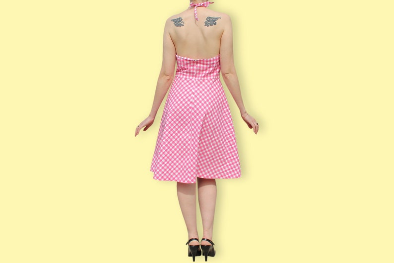 May include: A pink and white gingham halter dress with a fitted bodice and a full skirt.