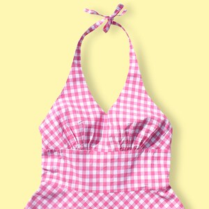 May include: A pink and white gingham halter dress with a V-neckline and a gathered bodice.