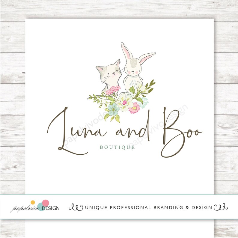 May include: A logo design for a boutique called "Luna and Boo" featuring a white bunny and a white cat with pink and blue flowers.