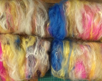 May include: Six skeins of colorful yarn, each with a blend of white, yellow, pink, blue, and brown fibers. The yarn is fluffy and soft, perfect for knitting or crocheting.