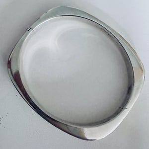 Sterling silver bangle bracelet oval shaped wide side cool and interesting.