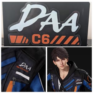 May include: Black sticker with the text "DAA" in white and "C6" in orange. The image also shows a close-up of a black and blue jacket with the "DAA" logo and a person wearing a similar jacket.