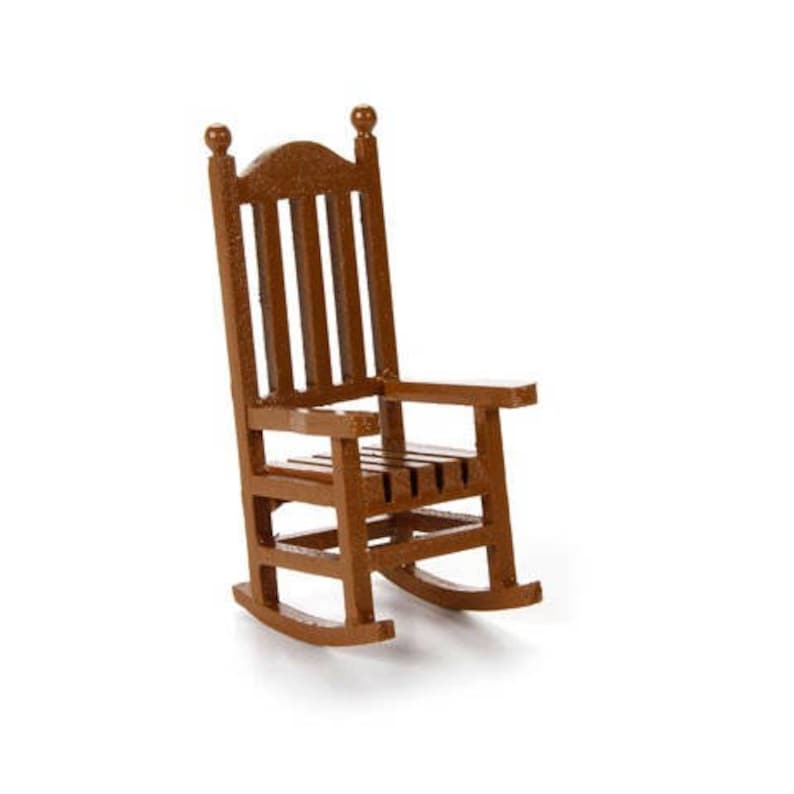 Op de afbeelding: Een bruine houten schommelstoel met een latten rugleuning en zitting. De stoel heeft een gebogen basis en is gemaakt van massief hout.