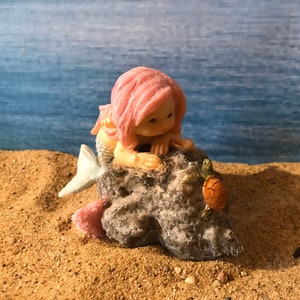 Pretty miniature mermaid playing with turtle on rock fairy garden mermaid with pink flowing hair beach nautical miniature playful mermaid