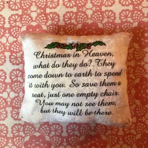 May include: White pillow with a message that reads "Christmas in Heaven, what do they do? They come down to earth to spend it with you. So save them a seat, just one empty chair. You may not see them, but they will be there."