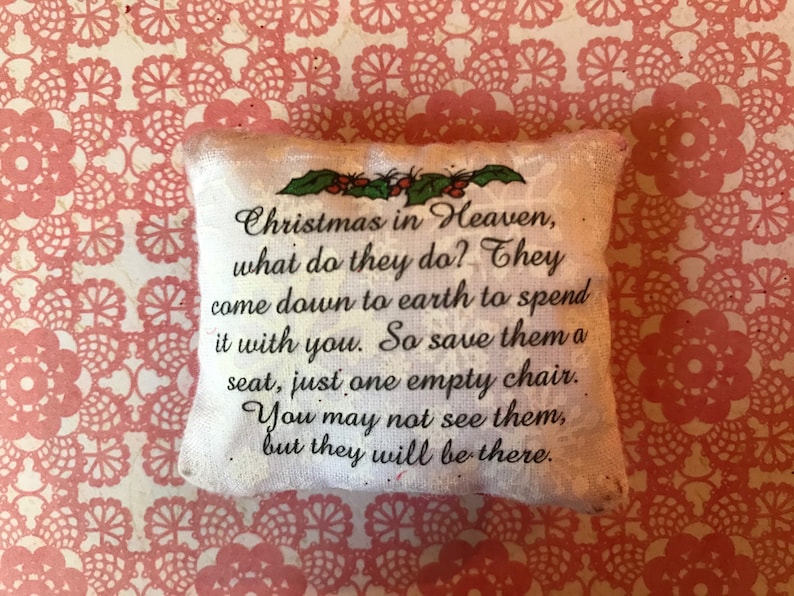 May include: White pillow with a message that reads "Christmas in Heaven, what do they do? They come down to earth to spend it with you. So save them a seat, just one empty chair. You may not see them, but they will be there."