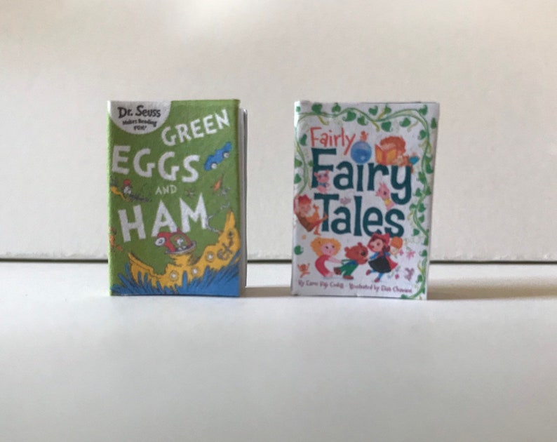 May include: Two children's books, one green with the title "Green Eggs and Ham" by Dr. Seuss, and the other white with the title "Fairly Fairy Tales" by Lora Bigler, illustrated by Dianna Chaney.