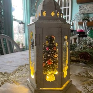 Pretty Christmas tree inside a white with gold accents lantern